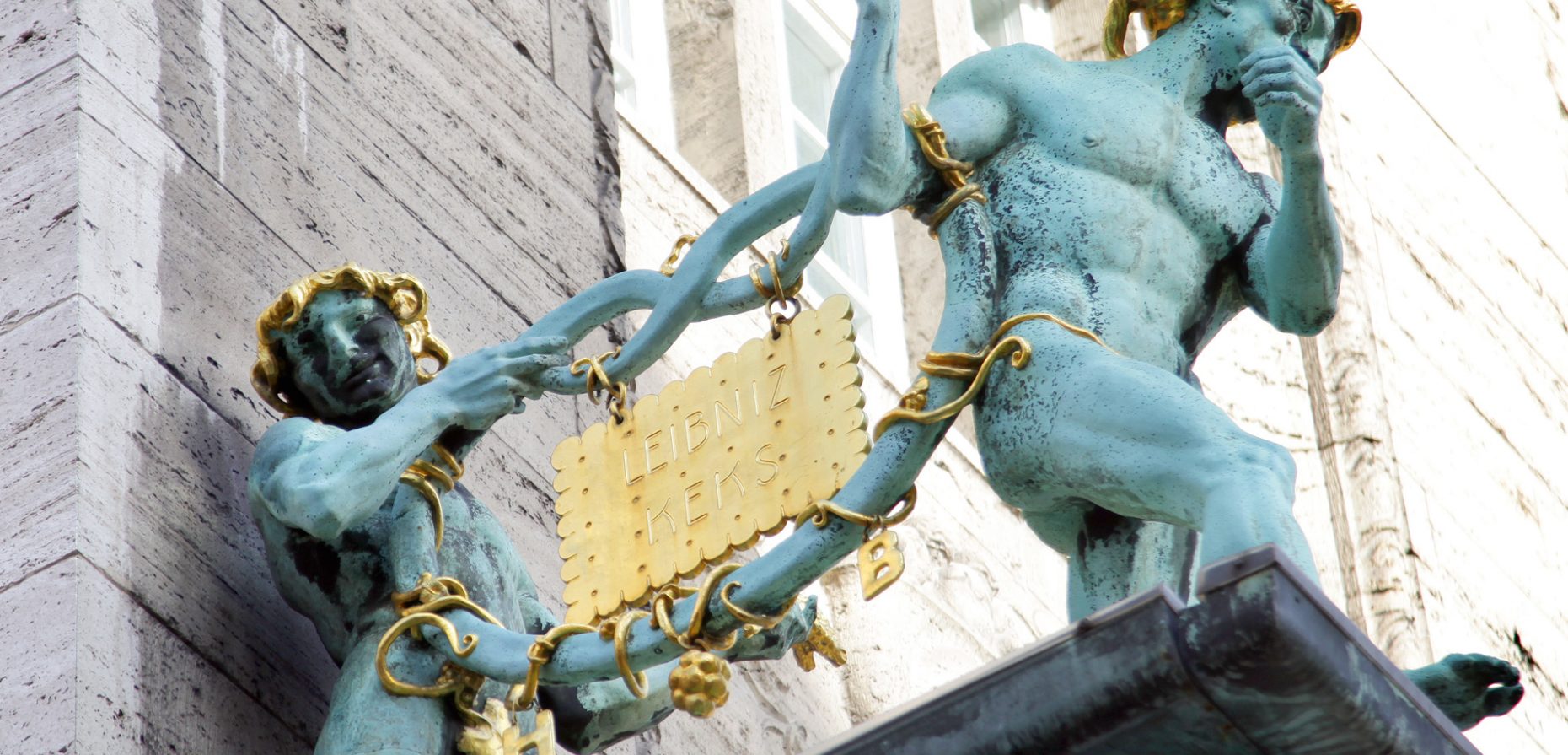 Der Leibniz-Keks ist die Ikone unter den Kleingebäcken und eine Lösung für ein Problem, mit dem sich bereits Gottfried Wilhelm Leibniz beschäftigt hat. Unser Titelbild zeigt die 1910 geschaffenen Brezelmännner mit dem „goldenen Keks“, welche die Bahlsen-Firmenzentrale in Hannover zieren.